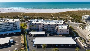 A beachfront hotel with multiple buildings, parking areas, and a view of the ocean and beach. - Good Vibrations- Stay right ON the beach in Siesta Key! Sleeps 6 (Siesta Key)
