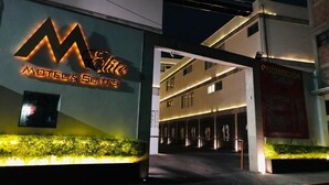 A modern building with a prominent 'Motel Suites' sign, a covered parking area, and a 'Promocion' sign advertising special offers. - HOTEL M DORADO (Mexico City)