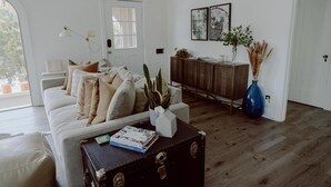 A living room with a sofa, a coffee table with a book, a cabinet, and a door.