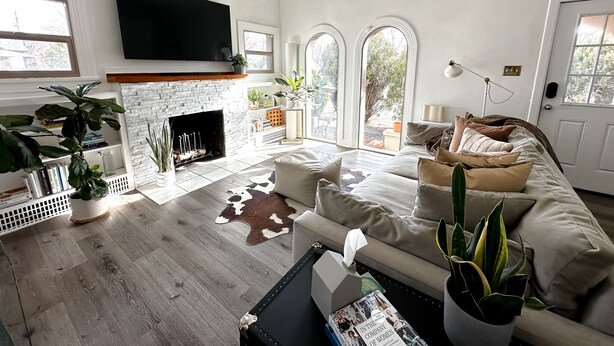 A modern living room with a fireplace, a large flat-screen TV, and a comfortable sofa.