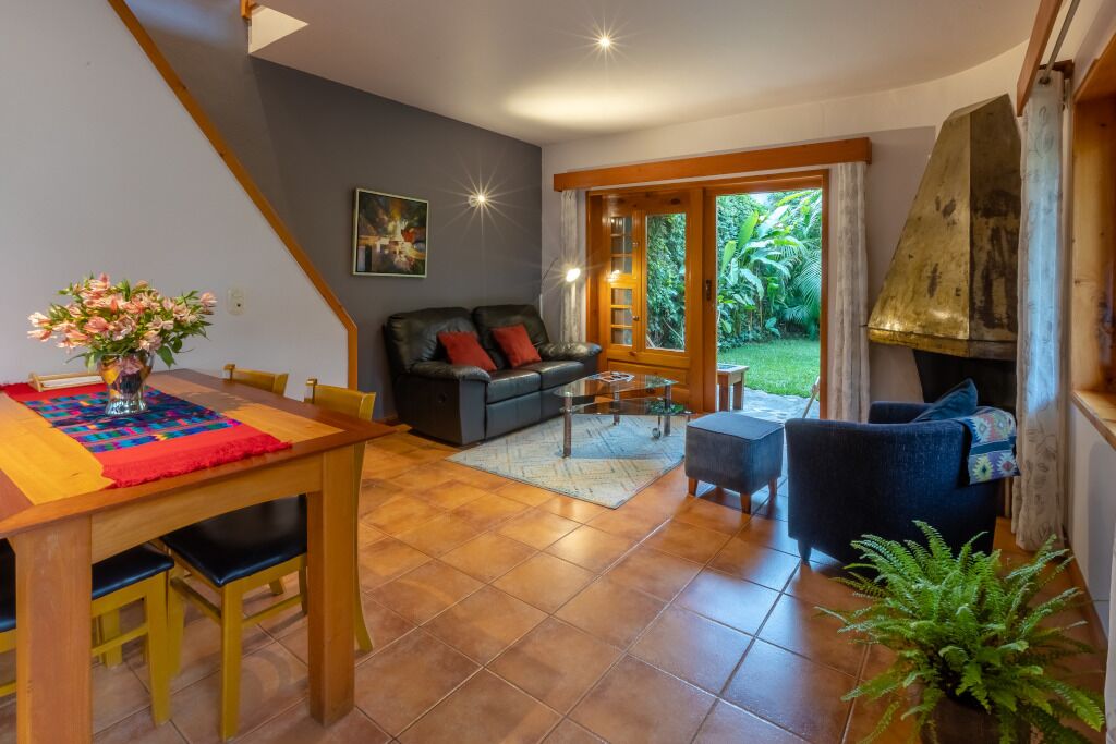 Amplia sala de estar con mesa de comedor, sofá y chimenea.