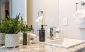 A bathroom with a sink, mirror, and various toiletries. - NEW - Mountain Chic Escape - Whyte Ave - Netflix - Clean!
 (Edmonton)