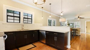 Una cocina moderna con armarios oscuros, una isla grande e iluminación colgante.
