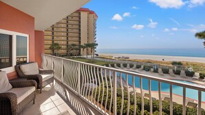 A balcony with wicker furniture, a pool, and a view of the beach and ocean. - 2nd fl. 2 br newly remodeled unit with Stunning Views! Beach chairs included! (Panama City Beach)