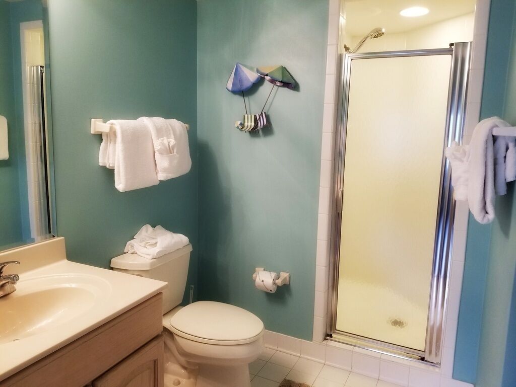 A bathroom with a toilet, sink, and shower.