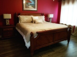 A large bed with a wooden frame, two bedside tables with lamps, and a painting on the wall. - Coral Reef Unit #301Specious 4br right on the water for big family vacations! (Panama City Beach)