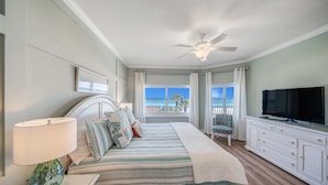 A bedroom with a bed, a TV, a ceiling fan, and a view of the ocean. - Beachfront 2br/2ba condo on the 3rd floor with free beach chairs included! (Panama City Beach)