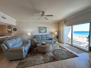 A living room with a ceiling fan, two sofas, a coffee table, and a view of the beach. - Coral Reef Unit#403 (Beachfront 2 bedroom 2 bath condo on the 4rth floor) (Panama City Beach)