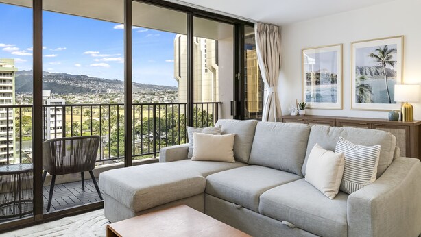 A balcony with a sofa, a chair, and a table. - Waikiki Golden Gem: 1 Br w/ Free Parking (Honolulu)