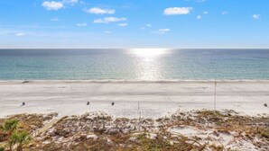 A beach with a clear sky, calm sea, and a sandy shore with sparse vegetation. - Coral Reef Unit#706 (Beachfront 4 bedroom 3 bath condo on the 7th floor) (Panama City Beach)