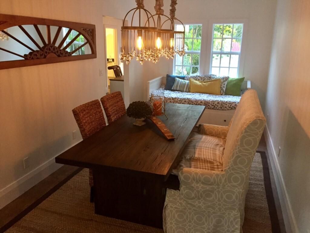 A dining area with a wooden table and chairs, a bench with cushions, and a decorative wall piece.