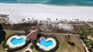 An aerial view of a resort with two swimming pools, a beach, and a bridge connecting to the beach. - Coral Reef Unit #1405 Beachfront 2 bedroom 2 bath condo on the TOP floor!!! (Panama City Beach)
