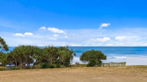 A coastal landscape with a clear view of the ocean, a grassy area, and dense vegetation. - Pearls on Sapphire Beach (Sapphire Beach)