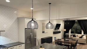A modern kitchen with a central island, stainless steel appliances, and pendant lighting. - Luxe Nashville 3-bedroom Townhouse w/rooftop deck (Nashville)