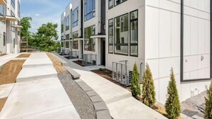 A modern building with multiple floors, large windows, and a clean, organized exterior. - Luxe Nashville 3-bedroom Townhouse w/rooftop deck (Nashville)