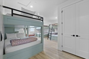 A bunk bed room with a ladder, a wardrobe, and a window. - Brand New Home! Roof Top Deck, Games for everyone, Private Pool (Hurricane)