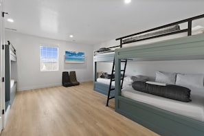 A bunk bed room with a window, a painting, and a desk. - Brand New Home! Roof Top Deck, Games for everyone, Private Pool (Hurricane)