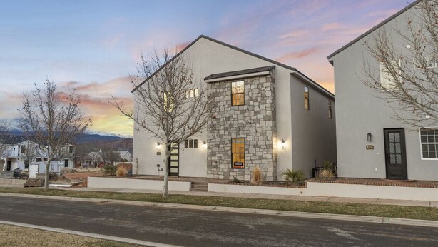 A modern two-story building with a stone facade, a black door, and a well-lit entrance. - Brand New Home! Roof Top Deck, Games for everyone, Private Pool (Hurricane)