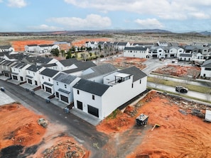 Zona residencial con casas modernas, una avenida principal y obras en construcción.