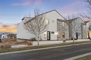 A modern two-story building with a stone facade and a flat roof.