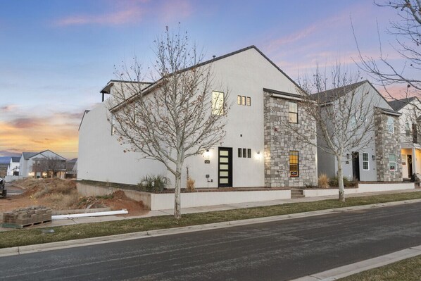A modern two-story house with a stone facade and a white exterior.