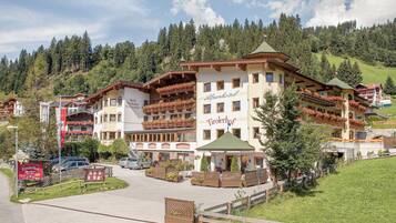 Un hotel con varios balcones, un letrero que indica que es un restaurante y vistas a un paisaje montañoso.