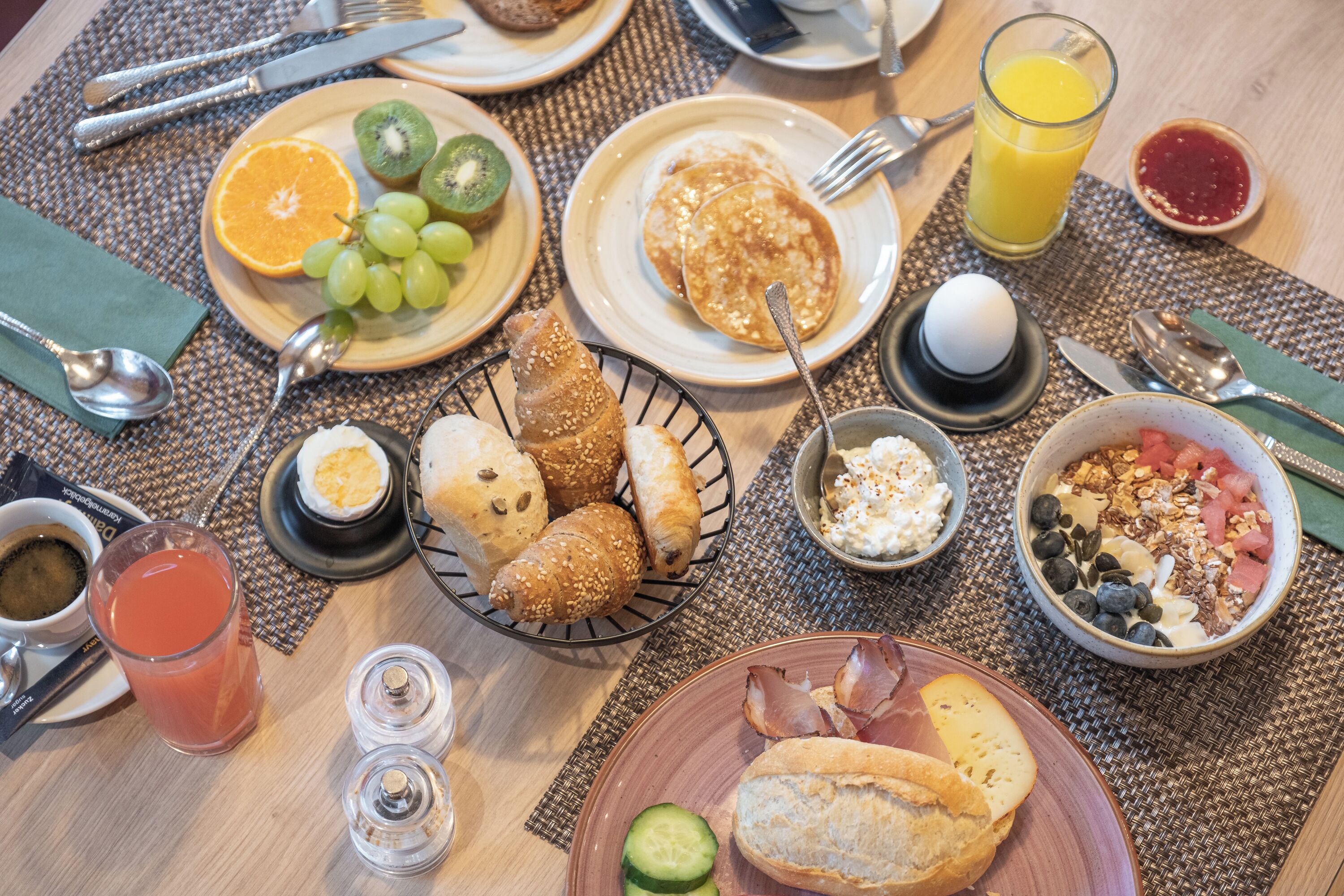Une table de petit-déjeuner avec divers aliments et boissons.