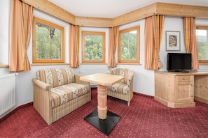 Suite Deluxe, balcón, vista a la montaña | Área de sala de estar | Televisión de pantalla plana de 32 pulgadas con canales por cable
