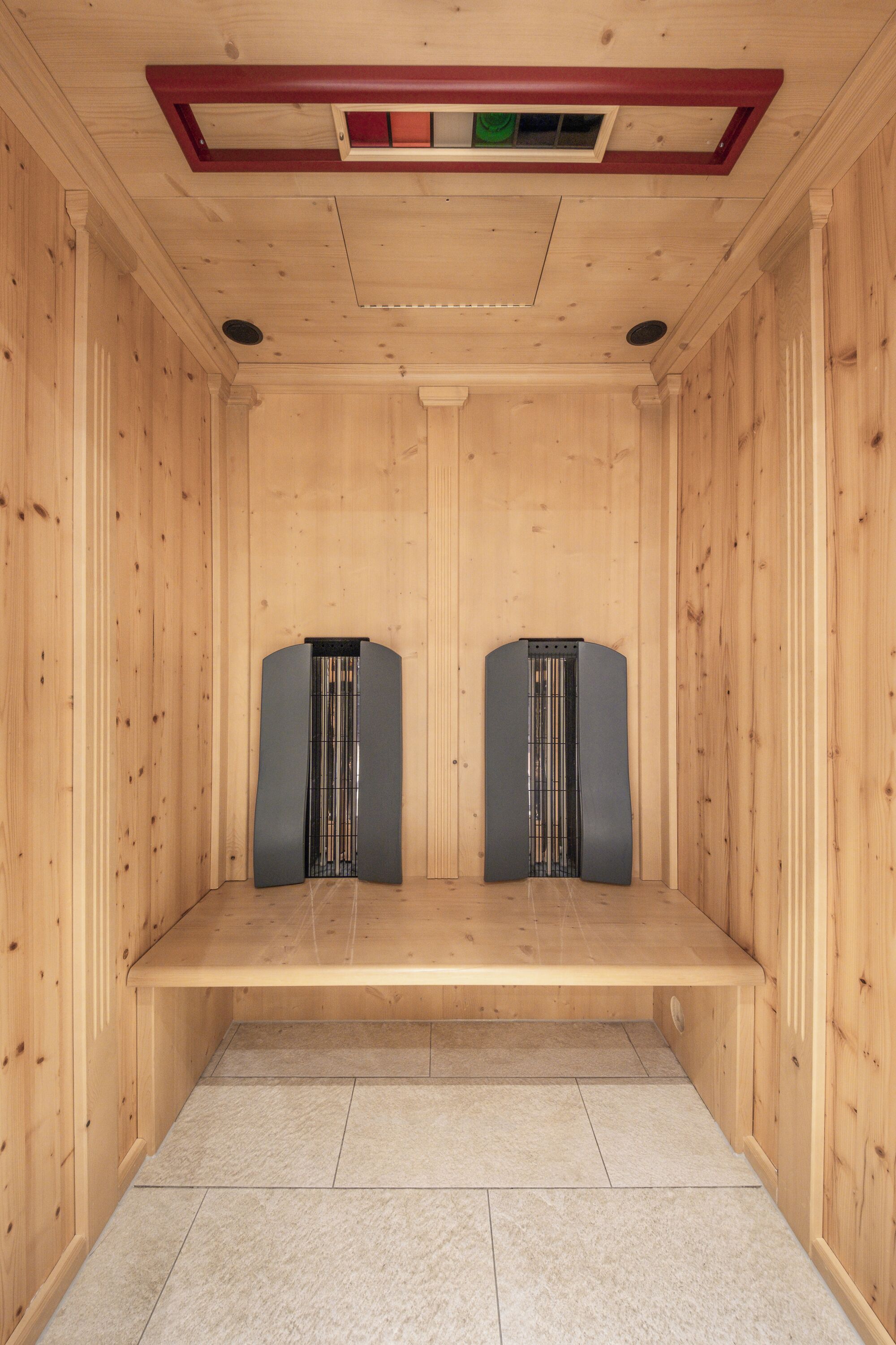 Una sauna con paredes de madera y un banco.