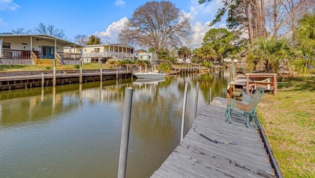 A waterfront property with a dock, a boat, and a small dockside seating area. - Pensacola Home w/ Private Dock - 7 Mi to Beaches (Pensacola)