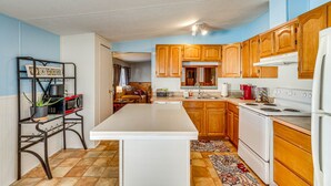 A kitchen with wooden cabinets, a white countertop, and a central island. - Pensacola Home w/ Private Dock - 7 Mi to Beaches (Pensacola)