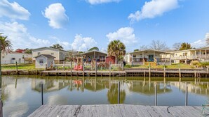 A waterfront property with docked boats, a wooden deck, and a row of beach houses. - Pensacola Home w/ Private Dock - 7 Mi to Beaches (Pensacola)