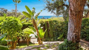 Un jardín con un sendero de piedra que lleva a una vista del mar.