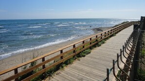 A wooden boardwalk along a beach with the ocean in the background. - 1370 Mi Capricho Calahonda Holiday Rental (Mijas)