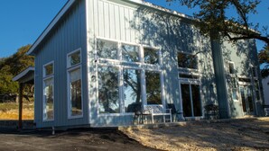 Un bâtiment en bois de couleur bleu clair, doté de grandes fenêtres et d’un porche abrité.