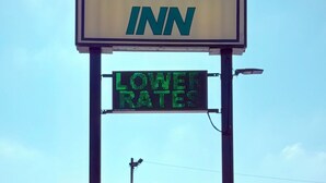 Schild des Regency Inn mit einer digitalen Anzeige, die ‚GERINGERE PREISE‘ bewirbt.