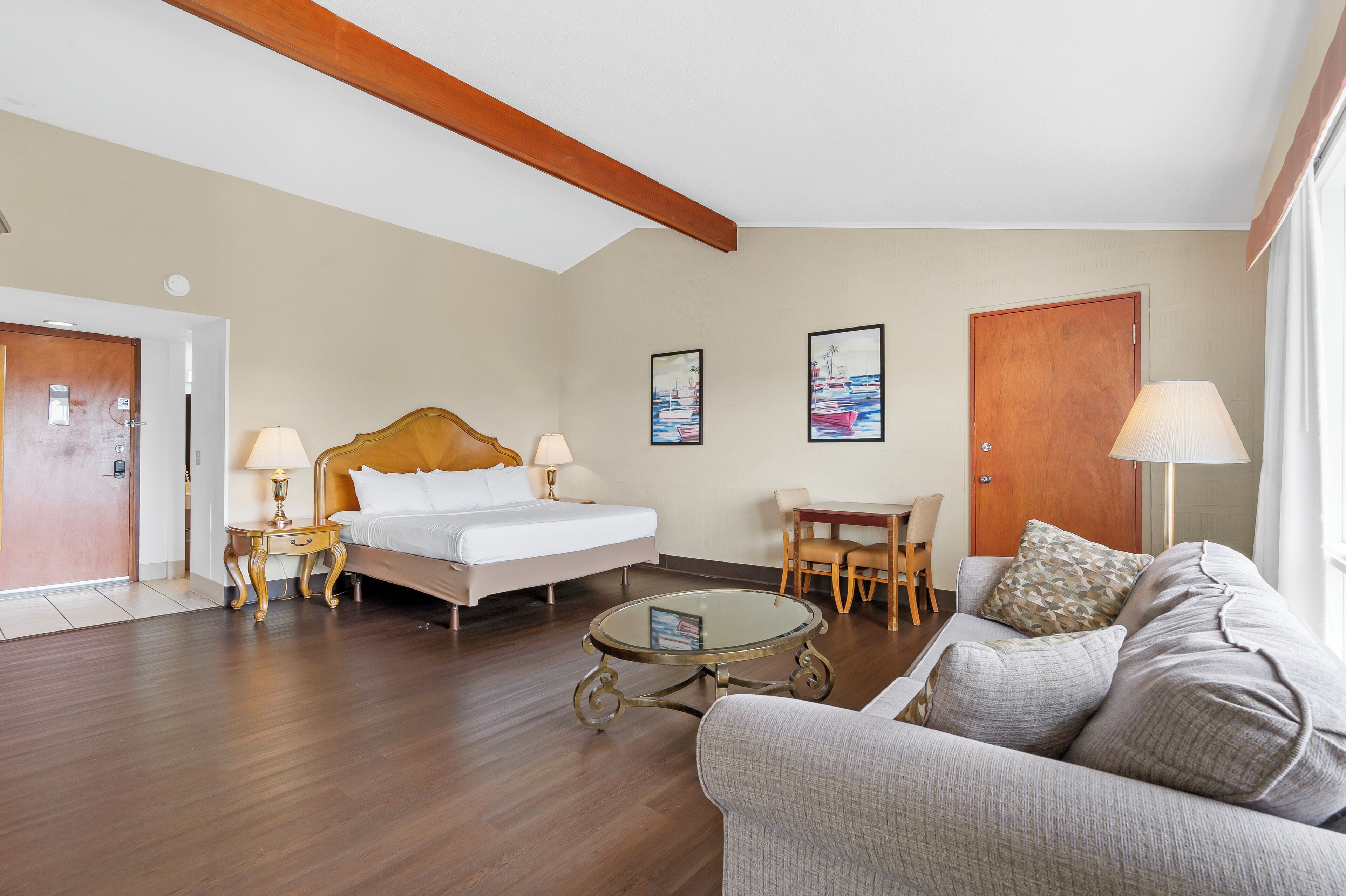 Ein Hotelzimmer mit einem Bett, einer Couch, einem Esstisch und einem kleinen Couchtisch.