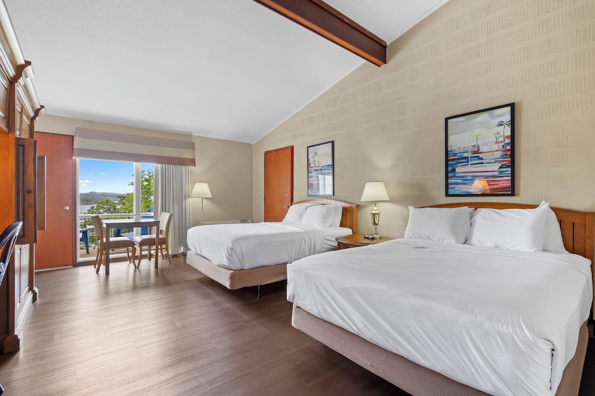 Une chambre d’hôtel avec deux lits, un balcon et une vue sur l’extérieur.