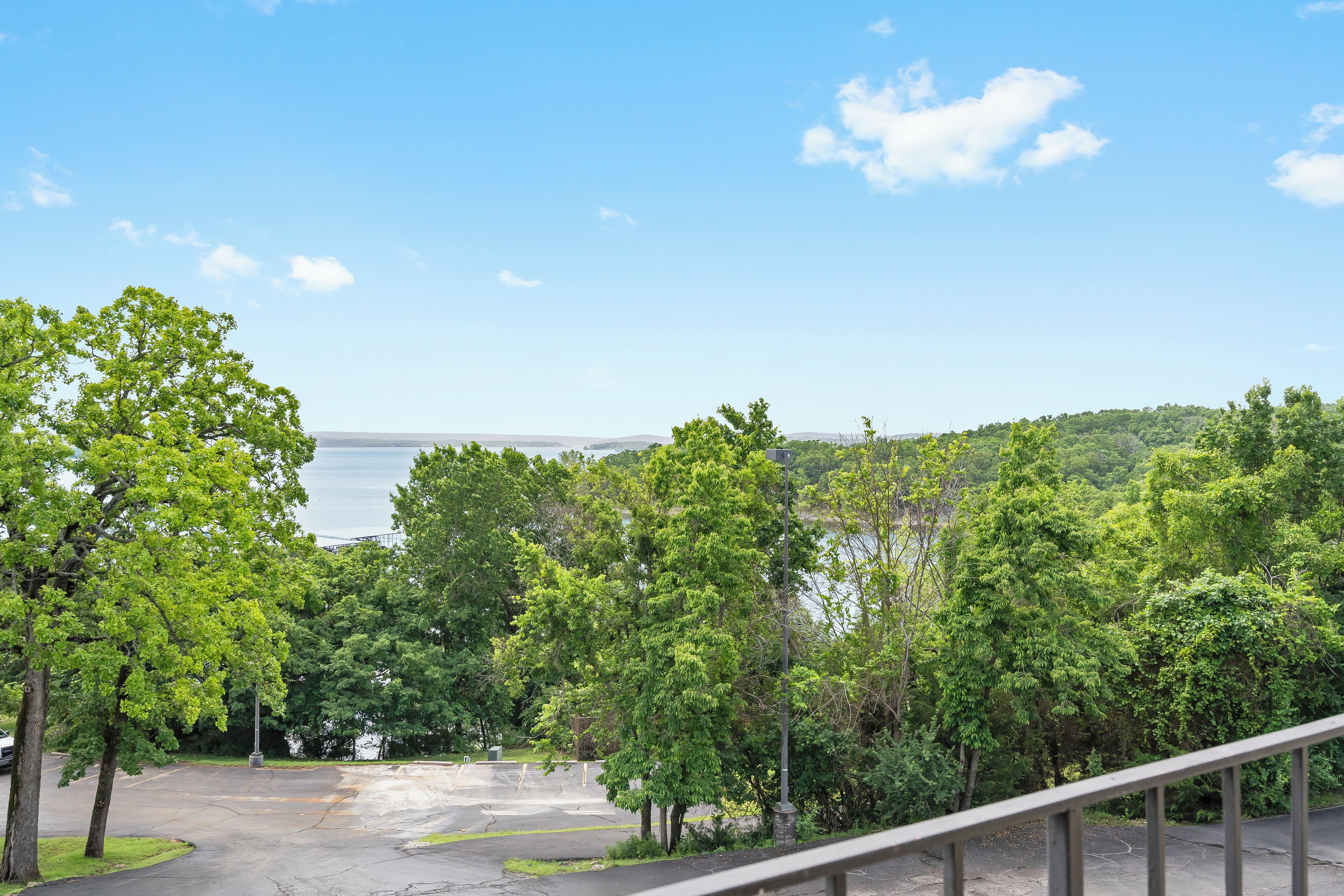 Area di parcheggio con alberi e vista su un corpo d'acqua.