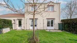 A two-story house with a tiled roof, a small front yard, and a tree in the center. - La Merisolle - 850m mer - Wifi (Pornic)