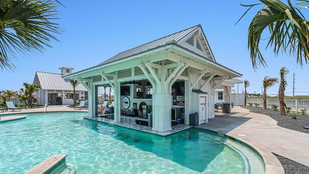 A pool area with a bar structure, clear water, and palm trees.