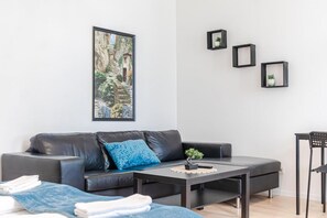 Un salon moderne avec un canapé en cuir, une table basse et un tableau encadré accroché au mur.