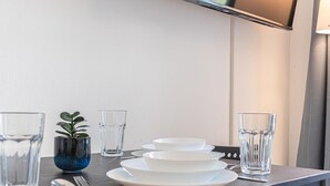 A neatly arranged dining table with plates, bowls, glasses, and cutlery. - Budget City Living: 1BR w/ Private Garden (Wien)
