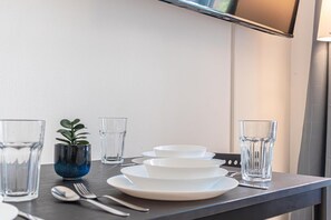 Une table à manger bien mise, avec des assiettes, des bols, des verres et des couverts.
