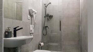 Ein Badezimmer mit Toilette, Waschbecken und Dusche.