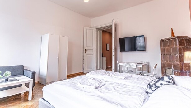 Une chambre à coucher comprenant un lit, un bureau, une chaise, une armoire et un téléviseur.
