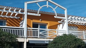A building with a balcony, a sign reading "Boulangerie," and a clear blue sky. - Bel Appartement Centre Biscarrosse Plage (BISCARROSSE)