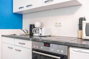 A kitchen with a microwave, coffee maker, and oven.