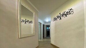 A hallway with a mirror, decorative wall art, and a rug. - Apartamento Amplio, Tranquilo , Cómodo y Seguro a 5 min de CC Buenavista, Viva (Barranquilla)