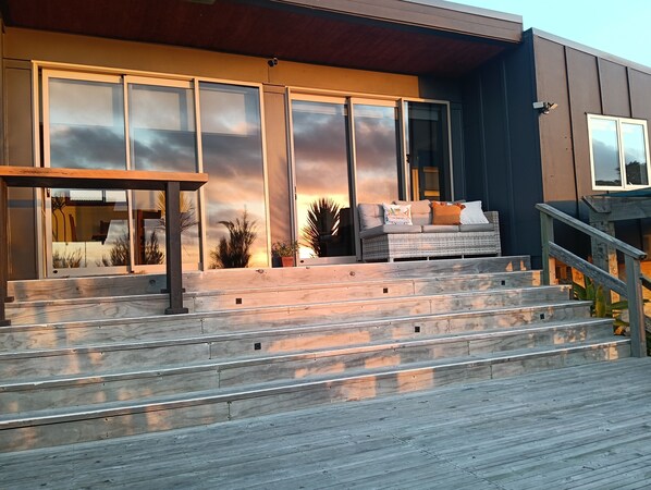 A modern building with a staircase leading to a seating area with a sofa and cushions.